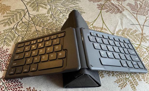 Targus foldable ergonomic keyboard. Extremely thin board opens like a book and here is opened over a glasses case so it forms a tent with each half of the keyboard on either side. 