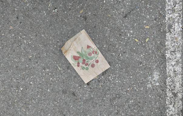 braune Packpapier-Obsttüte auf einer Asphaltbahn