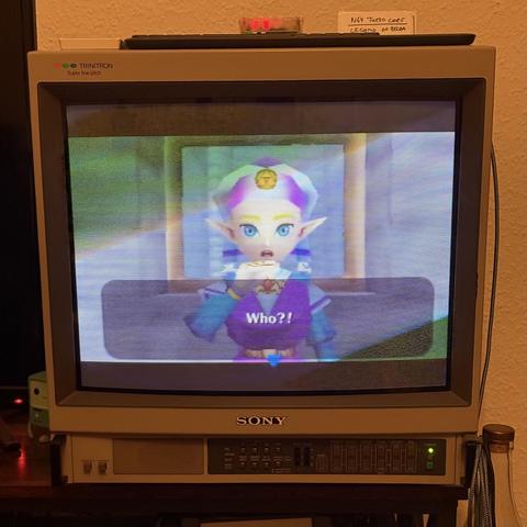An old television displaying a scene from a video game featuring a character with colorful hair and pointed ears, asking "Who?!"