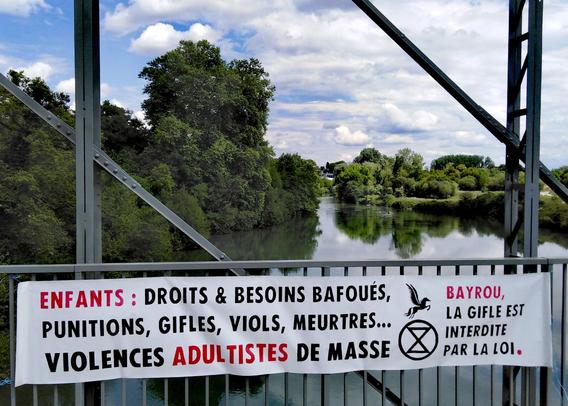 Banderole déployée sur un pont du Gave de Pau : ENFANTS : Droits & besoins bafoués, punitions, gifles, viols, meurtres... Violences adultistes de masse. Bayrou, la gifle est interdite par la loi.