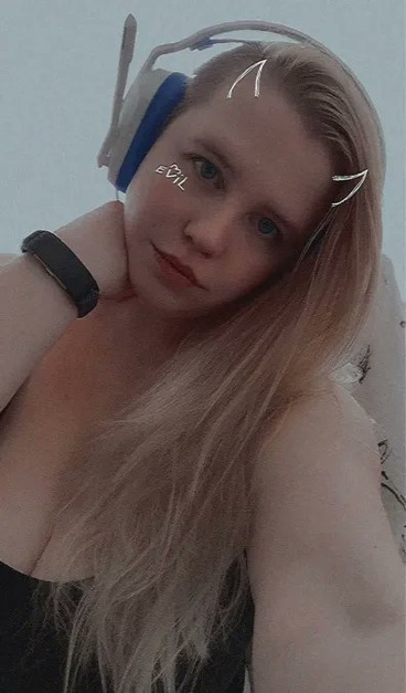 Selfie of Queen in a black tank top and blue and white headphones