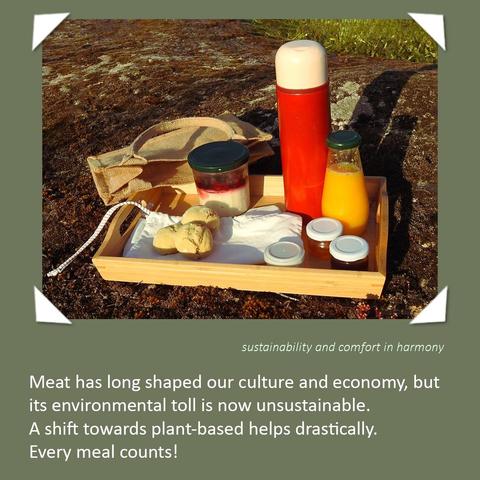 A wooden tray sits on a mossy rock outdoors, holding a vegan breakfast. It includes a glass jar of vegan yogurt topped with berries, a bright orange juice, a red thermos with coffee, two homemade jams, olive oil spread and three small breads. The image is bordered in olive green with white corner accents. Below the image, white text reads: “Meat has long shaped our culture and economy, but its environmental toll is now unsustainable. A shift towards plant-based helps drastically. Every meal counts!” A smaller italic caption in the corner says: “sustainability and comfort in harmony.