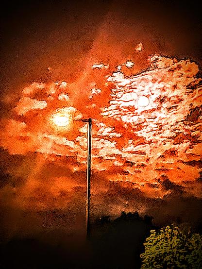 ..this too has a redish tinted sky, with the moon juxtaposed with a single street lamp centrally located in the image..