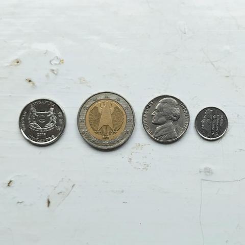 Four coins in a row hailing from: Singapore, EU, USA, Netherlands (prior to Euro adoption!). 
