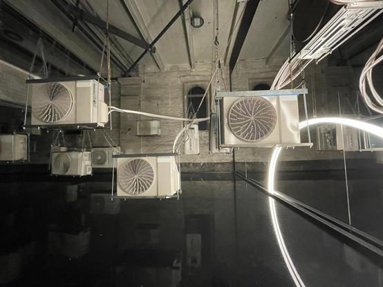 suspended air-conditioning units and a pool of what looks to be oil