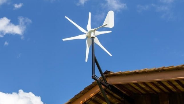 A small wind turbine with six blades, mounted on a shallow pitched roof of a domestic home