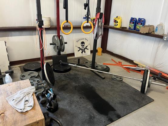 Wooden box, kettle bells, dumb bells and weights on rubber flooring