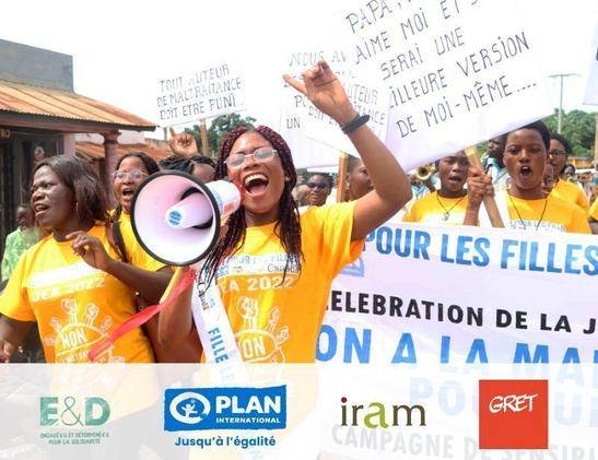 Groupe de jeunes femmes manifestant dans la rue avec haut parleur et pancartes