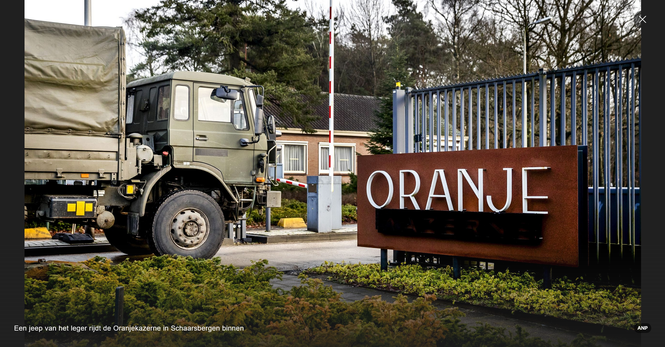 Een vrachtwagen van het leger rijdt door een kazernepoort. Onderschrift: "Een jeep van het leger rijdt de Oranjekazerne in Schaarsbergen binnen."