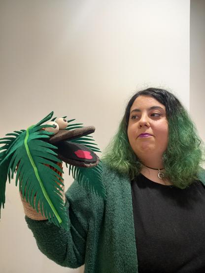 Foto donde sale una marioneta de mano que es una palmera mientras la llevo puesta y la miro.