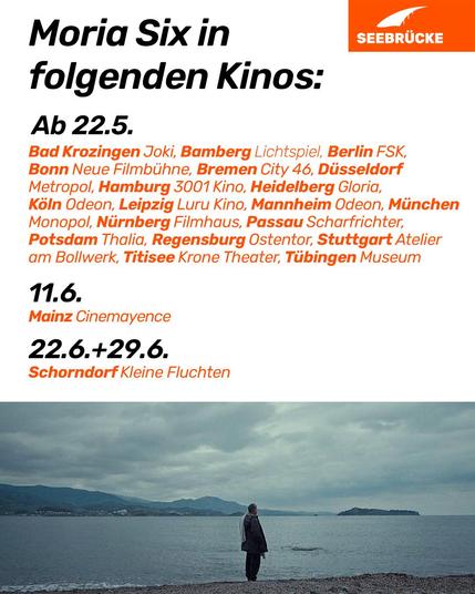 Foto einer Person vor einem Gewässer. Oben steht auf weißem Hintergrund “Moria Six in folgenden Kinos:

Ab 22.5. Bad Krozingen Joki, Bamberg, Lichtspiel, Berlin FSK, Bonn Neue Filmbühne, Bremen City 46, Düsseldorf Metropol, Hamburg 3001 Kino, Heidelberg Gloria, Köln Odeon, Leipzig Luru Kino, Mannheim Odeon, München Monopol, Nürnberg Filmhaus, Passau Scharfrichter, Potsdam Thalia, Regensburg Ostentor, Stuttgart Atelier am Bollwerk, Titisee Krone Theater, Tübingen Museum

11\.6. Mainz Cinemayence

22\.6.+29.6. Schorndorf Kleine Fluchten”. In der rechten oberen Ecke ist das Seebrücke-Logo in weiß auf orange.