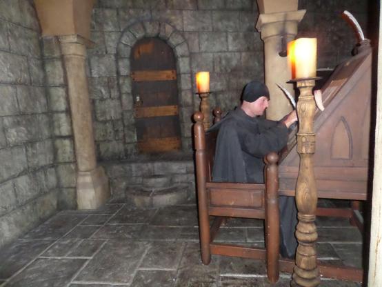  Further ahead on the left, two #Benedictine Monks (11th and 12th-century) are seated at their desks copying text. The one on the right has fallen asleep at the job. His chest rises and falls as he breathes in and out.