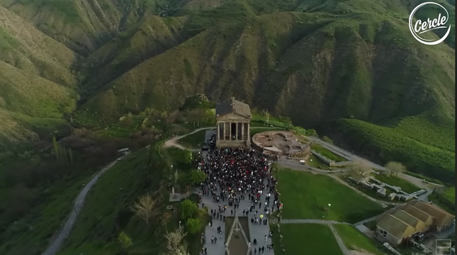 Garni Temple shot from the air probably by a drone, sitting on top of hill and surrounded by steep hills. There is a crowd gathered at its basis.
It is a classical colonnaded structure in the village of Garni, in central Armenia, around 30 km (19 mi) east of Yerevan.