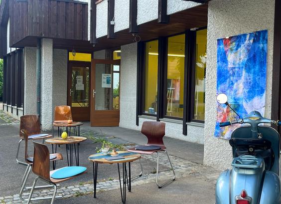 Außenansicht des Artspace Wieweg in Kirchheim Teck, Außensitzplätze, große Glasfront, Kunst an der Wand.