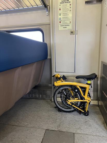my bright yellow Brompton folding bike, compactly folded for ease of riding the train. It takes up about as much space as a carry-on bag. Maybe less. 