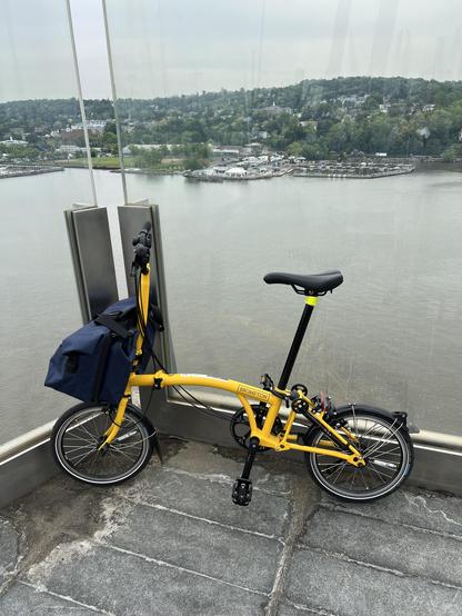 my bright yellow Brompton bike—unfolded and looking over the Hudson River on the Mario Cuomo Bridge bike path. 