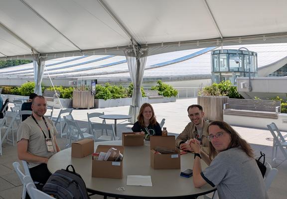 Eugene, Marie, Simon, and Yngve sitting at a table chatting about weird and fun things only vaguely related to PyCon