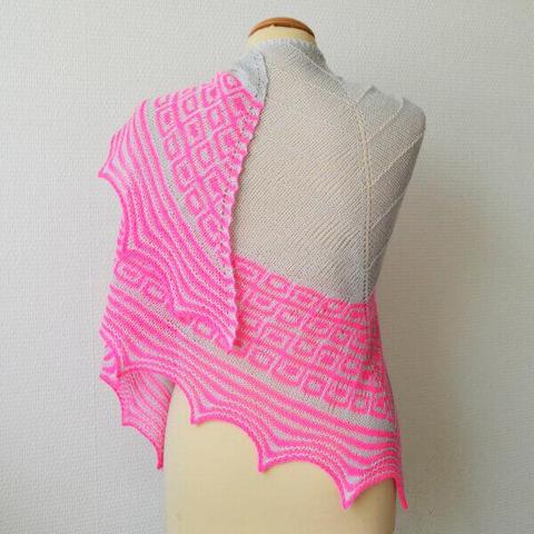 A knit shawl shown from the back on a mannequin against a white background. It has a textured body in light gray, and hot pink mosaic patterning as well as garter stitch stripes in the border.