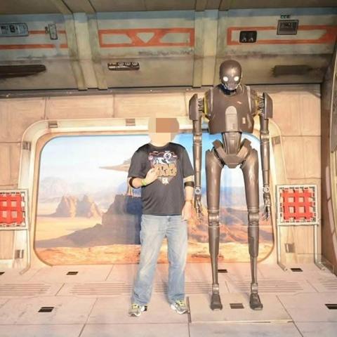 Picture of a man at a photo op with K-2SO from "Rogue One".