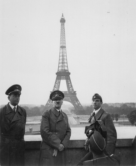 Albert Speer, Adolf Hitler, and Arno Breker on Trocadéro in front of the Eiffel Tower. A crouching cameraman films Hitler for the cinema newsreel. Paris, 23 June 1940. ( Photo collection: National Archives and Records Administration, USA )