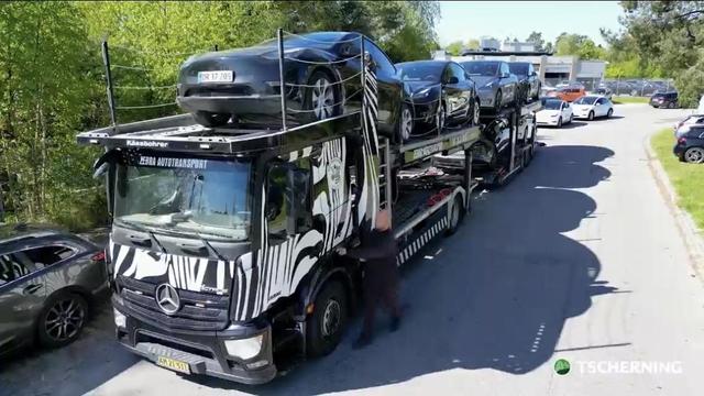 Still from a video of the company Teslas being picked up by man with a large truck.