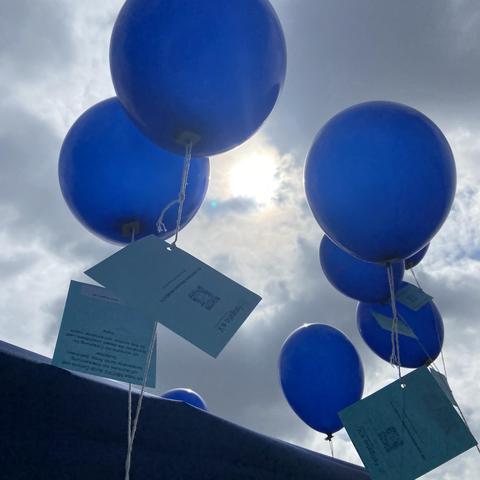 Foto des Fatigatio e.V. vom Info-Stand des Vereins auf der LiegendDemo am 10. Mai 2025 in Berlin. Auf dem Foto blaue Ballons mit Botschaften der Betroffenen. Weitere Fotos auf der Website.