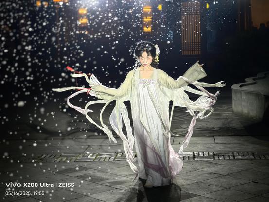 beautidul cbinese dancer with classic chinese clothing and mask in hand dancing with fake snowflakes flying through the air and bright back light.
Taken with Vivo X200 Ultra