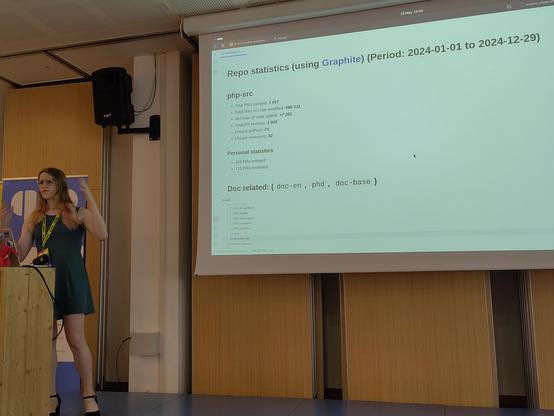 Gina standing in front of a projector slide showing general PHP foundation project statistics