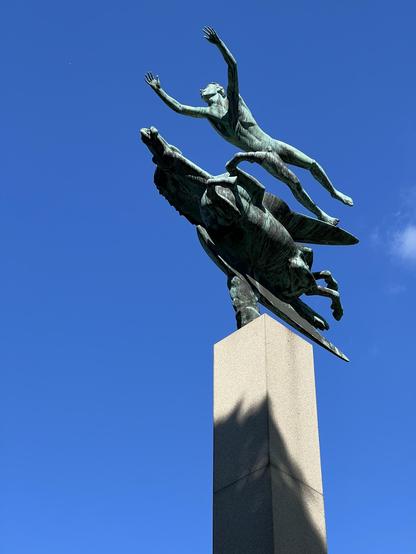 A statue on top of a column. A man and Pegasus.