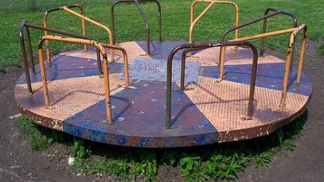 Rusty, bent playground carousel from yesteryear