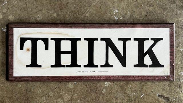 Tame the creative mind! Photograph of a 1960s IBM Corporation wooden wall sign laminated plaque with the word "THINK" in large letters and the phrase "COMPLIMENTS OF IBM CORPORATION" in small letters underneath.