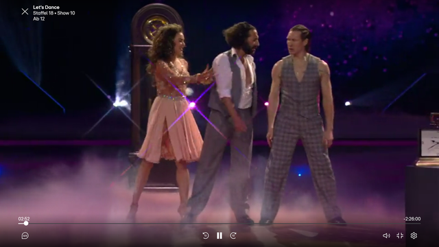 Trio Opening dance mit Massimo, Evgeny und Renata in "Let's Dance 18x10)". Alle Drei konkurieren und tanzen miteinander. Hier stehen alle Drei nebeneinander auf der Tanzfläche in ihren Kostümen. Massimo in der Mitte wendet sich Evgeny zu seiner Rechten zu, während Renata zu Massimos Linken sich ihm zuwendet und ihn für sich gewinnen will.
