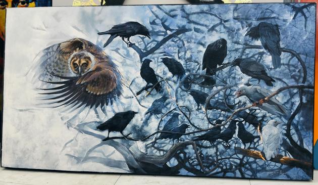 a  painting, it is wide horizontally, it is a large owl flying behind a leafless tree in a foggy forest, the tree full of black birds, some of them grey 