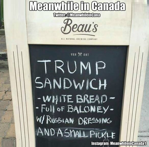 A bistro sandwich board written in chalk "Trump Sandwich - white bread - full of baloney - w/Russian dressing and a Small Pickle"