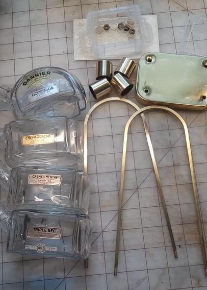 The bottles separated from the base for restoration. The parts of the decanter set are gathered together on a work bench. 
