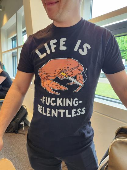 A shirt with an elderly-looking crab smoking, with text that reads "life is fucking relentless".