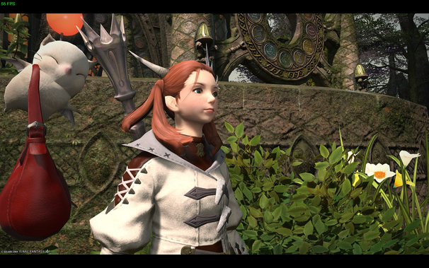 A character in Final Fantasy XIV stands in a garden setting. She has red hair in pigtails, fair skin with freckles, and wears a white and brown outfit. A Moogle is to her left, with a red pouch hanging alongside it. Behind them is a stone structure with a circular design, and a surrounding landscape of greenery and flowers.