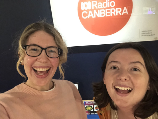 Two women in front of a red ABC Radio Canberra sign