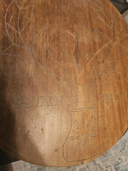 Tabletop that has Haiti etched into it. It also a flower vase in the center.