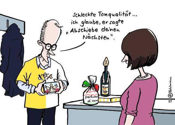 Friedrich Merz kommt nach der Amtseinführung von Papst Leo XIV.wieder nach Hause. Er trägt ein gelb-weißes Vatikan-Fan-Shirt und zeigt seiner Frau ein Handyvideo mit dem neuen Papst. Merz sagt: "Schlechte Tonqualität ... ich glaube, er sagte 'Abschiebe deinen Nächsten'."
Auf der Kommode im Hintergrund  liegen Souvenirs für seine Frau, ein Parfum aus Rom und eine Weinflasche in Papst-Optik.