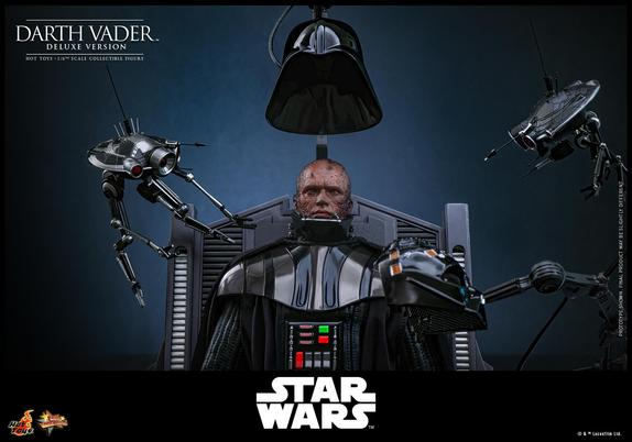 Image promotionnelle de la figurine de Darth Vader de chez Hot Toys, version Deluxe.
Au centre la figurine d'Anakin Skywalker brûlé, est en train d'être équipée de son casque et de son masque. Anakin est sur la table d'opérations telle que vue dans le film.
De part et d'autre de la figurine, deux droïdes semblent se concentrer sur les actions en cours.
Anakin porte donc l'une des première armure de Darth Vader, on peut voir son panneau de contrôle, avec des interrupteurs rouges et verts.

En texte, il y a :
En haut à gauche : Darth Vader, Deluxe Version, Hot Toys, 1/6th scale collectible figure.
Sur la droite : Prototype shown, final product may be slightly different
En bas, de gauche à droite : le logo de Hot Toys, le logo Movie Masterpiece, le logo de Star Wars, et la notice de copyright et Trademark Lucasfilm Ltd.
