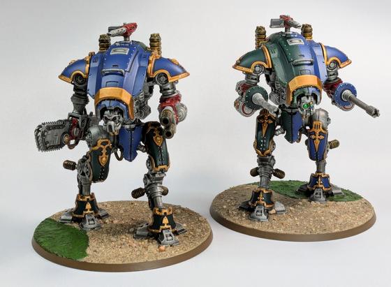 Two Knight Armiger models painted in blue and green with red weapons and gold trim.