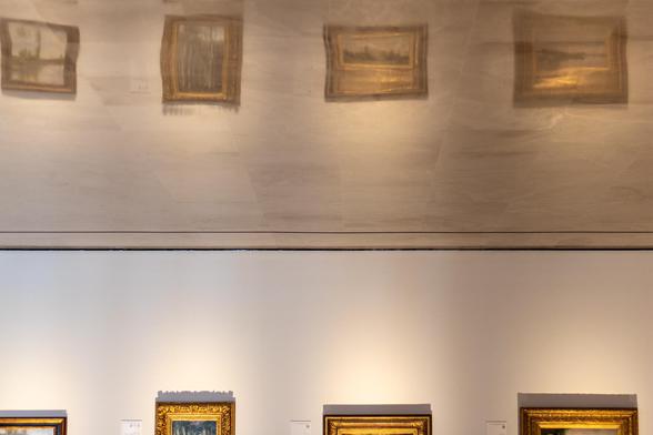 Fotografía donde se ven algunos cuadros reflejados en el suelo. La fotografía está tomada en el museo Carmen Thyssen de Málaga.