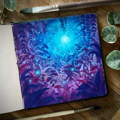 A photo of an open, square sketchbook, placed on a wooden table and surrounded by paint brushes and leaves for decoration. The sketchbook page features an overgrown hollow in purple, pink, and blue tones, with teal light flooding the scene from the back.
