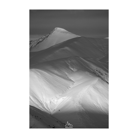 Winter photo of a summit before sunset with a soft light touching a summit