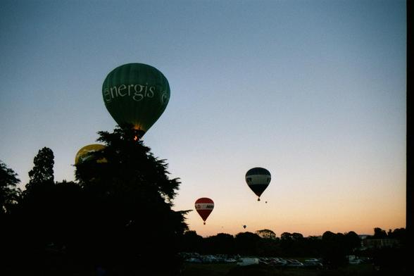 Hot air balloons flying in the sunset.