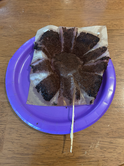 A non-standard cupcake wrapper that when opened looks like a chocolate flower with the long toothpick as the stem.