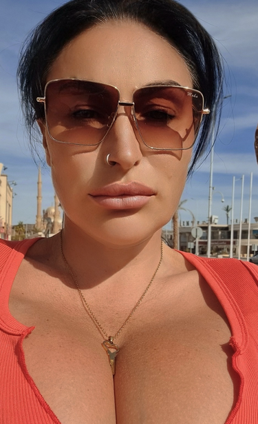 A cuckoldress walks down the street with her chastity Keyholder necklace on display. People look and know that she denies her husband sex.