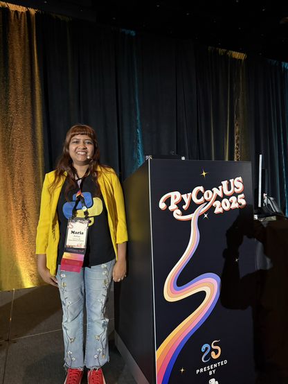 Maria Ashna on stage next to a PyCon US podium