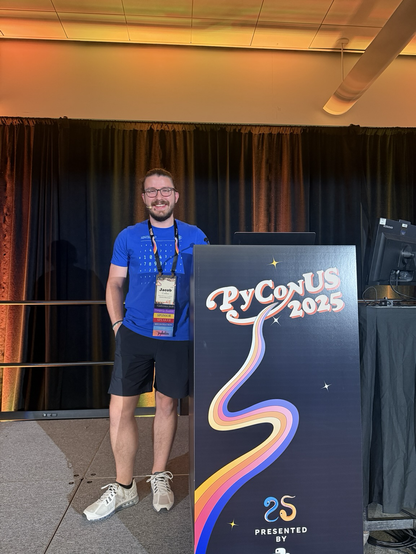 Jacob Coffee on stage next to a PyCon US podium